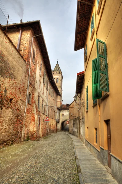Smalle straat onder oude huizen in saluzzo, Italië. — Stockfoto