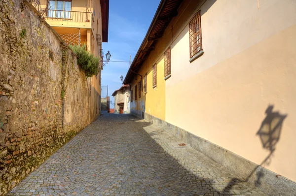 Taş döşeli dar sokak arasında evlerde saluzzo, İtalya. — Stok fotoğraf