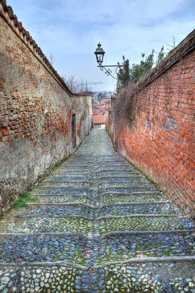 Liten gata bland gamla väggar i saluzzo, Italien. — Stockfoto
