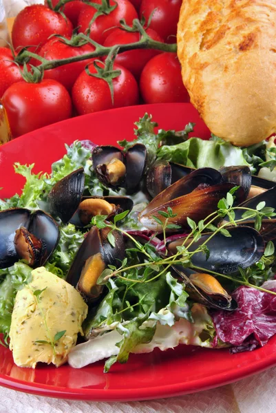 Cooked mussels with garlic butter sauce and thyme on fresh salad — Stock Photo, Image