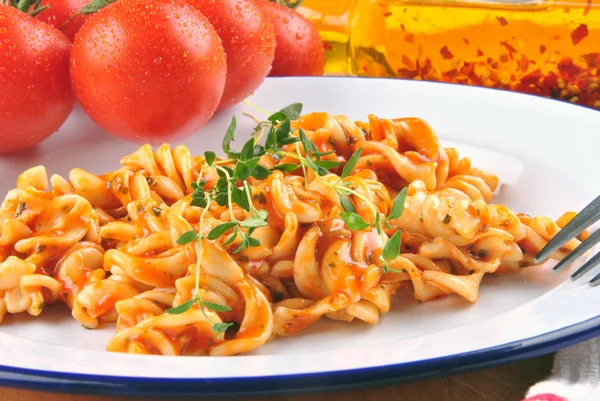 Ensalada de pasta casera en un plato con tomates frescos en la parte posterior —  Fotos de Stock