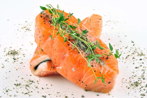 Filete de salmón con tomillo y pimienta machacada sobre un fondo blanco — Foto de Stock