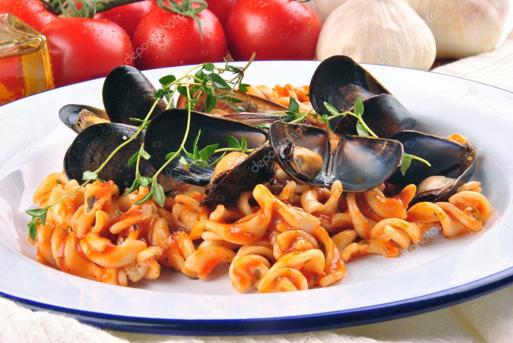 Homemade pasta salad on a plate with cooked mussels and fresh to