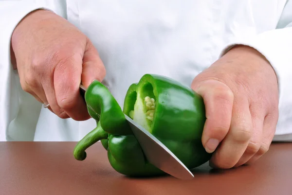 Femme chef préparant du paprika vert avec un couteau de cuisine — Photo