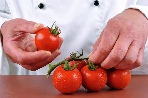 Ženské kuchař, v ruce držel pár čerstvých rajčat — Stock fotografie