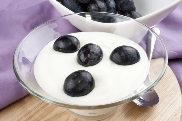 Modré hrozny s čerstvým jogurtem a lžičkou — Stock fotografie