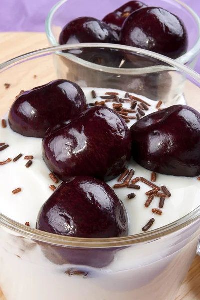 Jogurtti tuoreita makeita kirsikoita ja suklaa strösseleitä — kuvapankkivalokuva