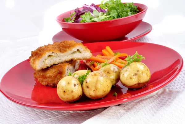 Vitlök kyckling kiev med unga potatis, morot remsor och färska — Stockfoto