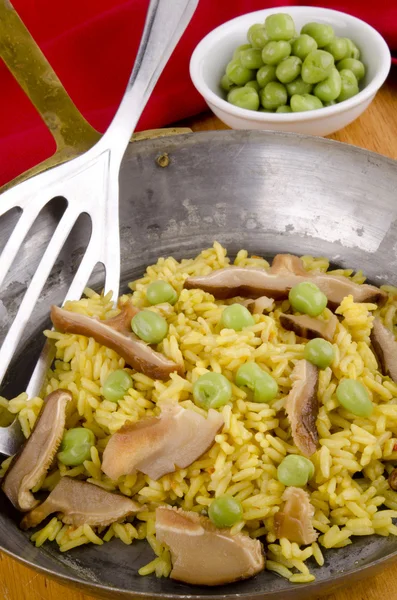 Golden rice in pan with mushrooms and pea — Stock Photo, Image