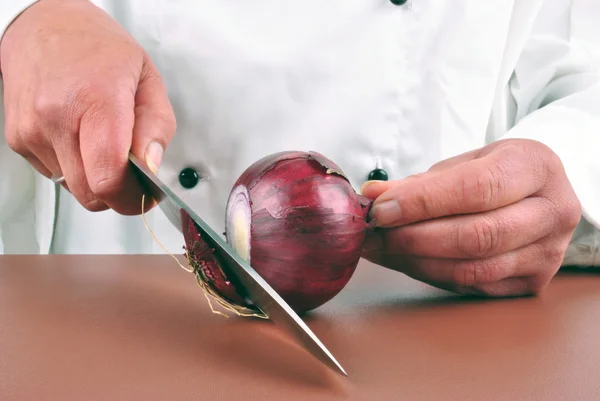 Θηλυκό σεφ περικοπές κρεμμυδιού λιλά με ένα μαχαίρι κουζίνας — Φωτογραφία Αρχείου