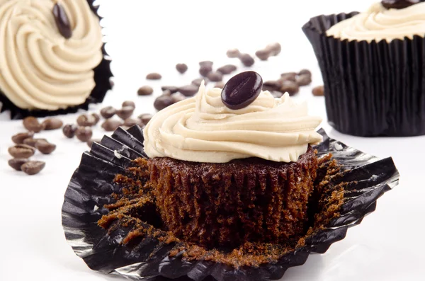 Hausgemachte Kaffee-Cupcakes und Kaffeebohnen im Hintergrund — Stockfoto