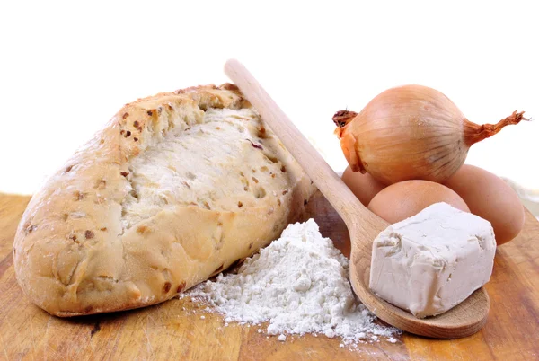 Pan de cebolla casero con ingredientes en una tabla de madera — Foto de Stock