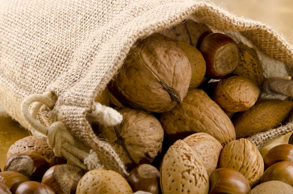 Various nuts in a brown jute bag — Stock Photo, Image