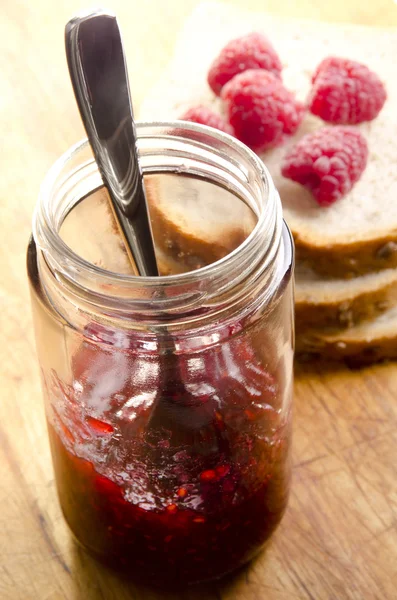 Huisgemaakte frambozenjam in een glas met een lepel — Stockfoto