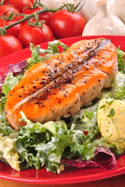 Salmon steak with green salad on a plate — Stock Photo, Image