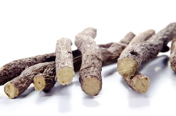 Liquorice root lying on a white surface — Stockfoto