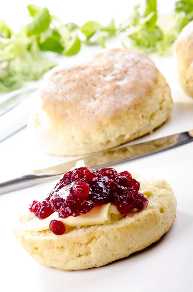 Scone spread with butter and cranberry jam — Stock Photo, Image