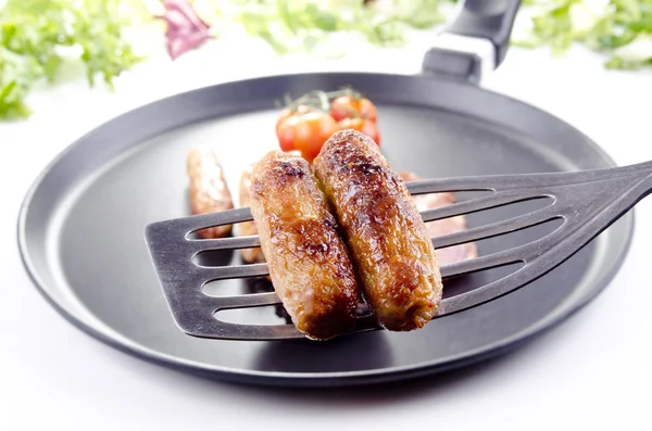 Two roasted sausages on a spatula — Stock Photo, Image