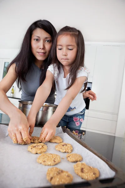 Mãe e criança fazendo biscoitos — Fotografia de Stock