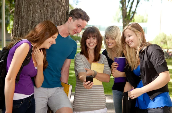 Studenti, směje se na telefon — Stock fotografie