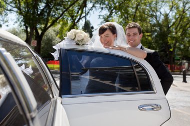 Bridge and Groom entering Limo clipart