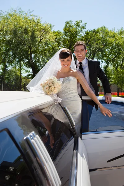 Hochzeitspaar mit Limousine — Stockfoto