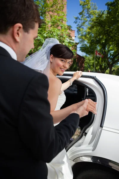 Nevěsta a ženich s limuzínou — Stock fotografie
