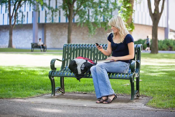 Chica universitaria usando teléfono celular — Foto de Stock