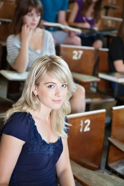 Портрет студентки, сидящей в аудитории — стоковое фото