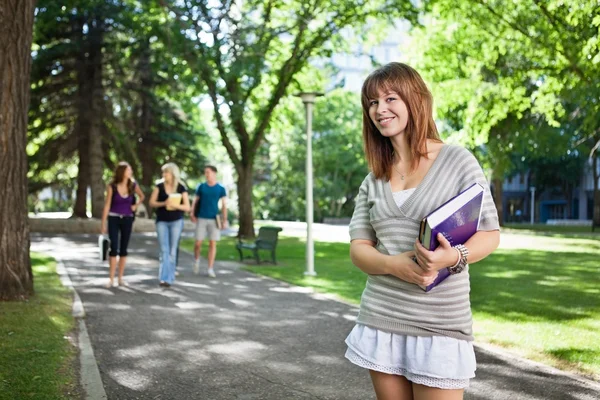 Menina da faculdade de pé com um livro — Fotografia de Stock