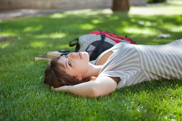Девушка лежит в кампусе колледжа — стоковое фото