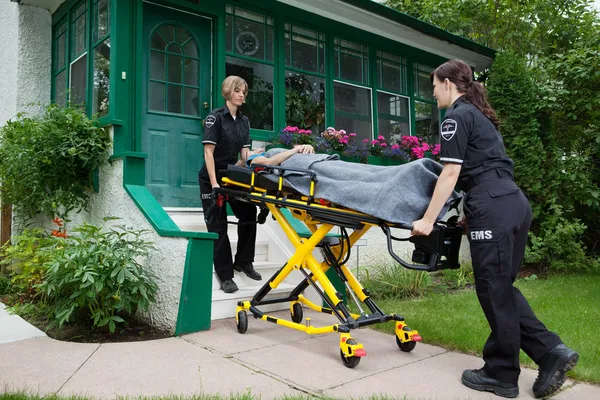 Ambulance werknemers met senior vrouw Stockfoto
