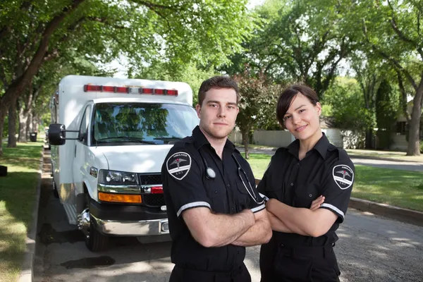Sjukvårdare stående med ambulans — Stockfoto