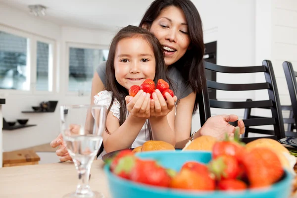 Mãe e filha na cozinha com morangos — Fotografia de Stock