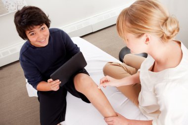 Child with Digital Tablet During Acupuncture clipart