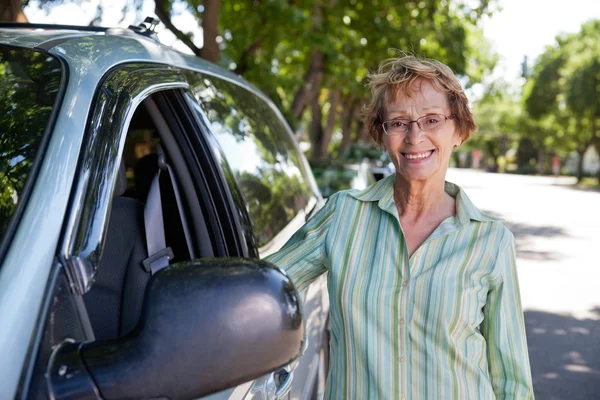 Senior woman standing near car — Stock Photo, Image