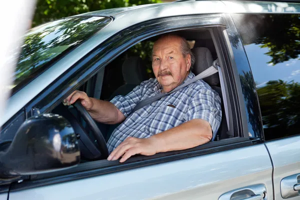 Senior man in een auto. — Stockfoto