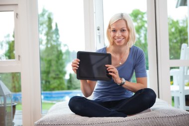 Young female holding tablet pc clipart