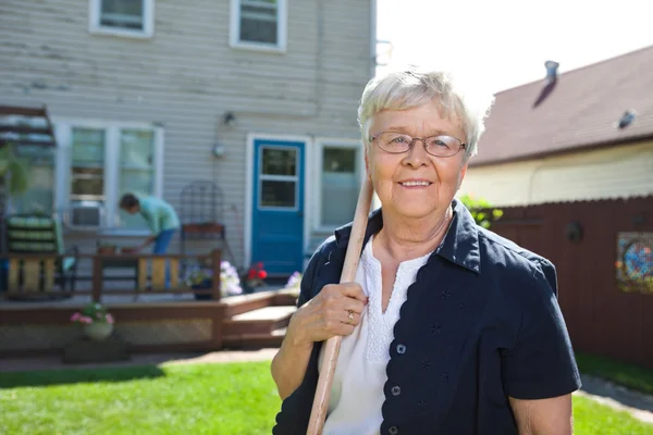 Senior mulher segurando ferramenta de jardinagem — Fotografia de Stock