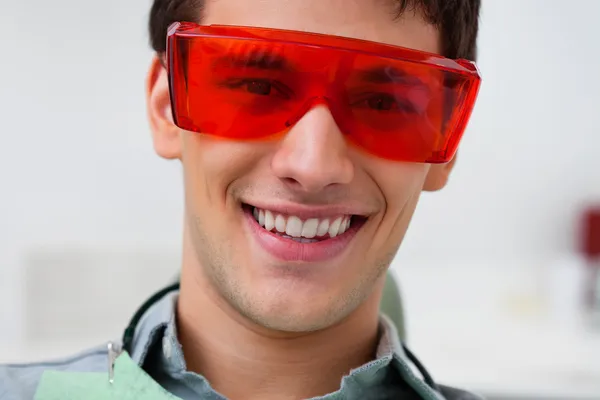 Bonito dentista vestindo óculos de proteção — Fotografia de Stock
