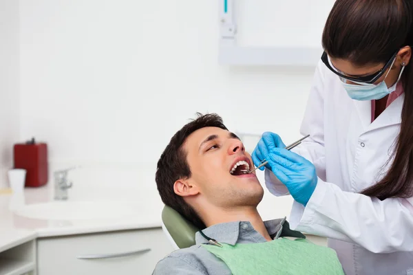 Lekarz dentysta badający pacjenta — Zdjęcie stockowe