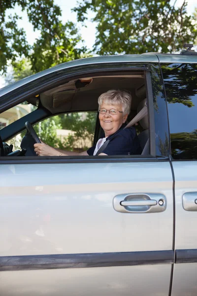 Прекрасная пожилая женщина за рулем автомобиля — стоковое фото