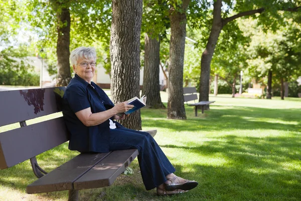 Woman reading book in a park — Stock Photo, Image