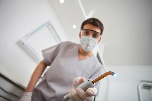 Стоматолог держит ультрафиолетовый свет — стоковое фото