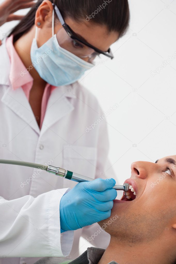 Dentist Using Drill on Patients Teeth