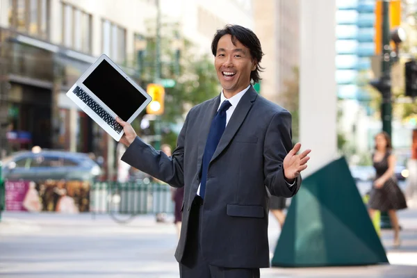 Empresario sosteniendo portátil y riendo — Foto de Stock