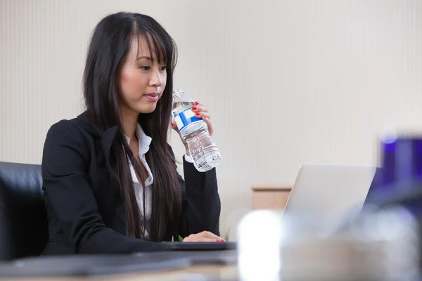 Бизнесвумен пьет воду на работе — стоковое фото