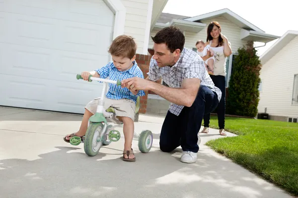 Pai ensinando filho a montar triciclo — Fotografia de Stock