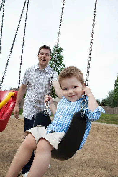 Father Pushing Son on Swing — Stockfoto