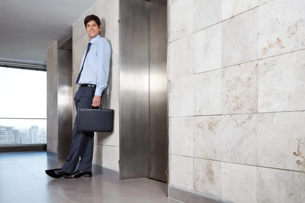Gerente corporativo guapo de pie cerca de ascensor —  Fotos de Stock